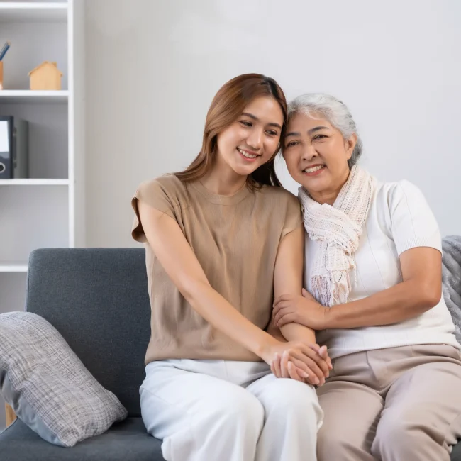 smiling-woman-and-senior-woman-sitting-on-sofa
