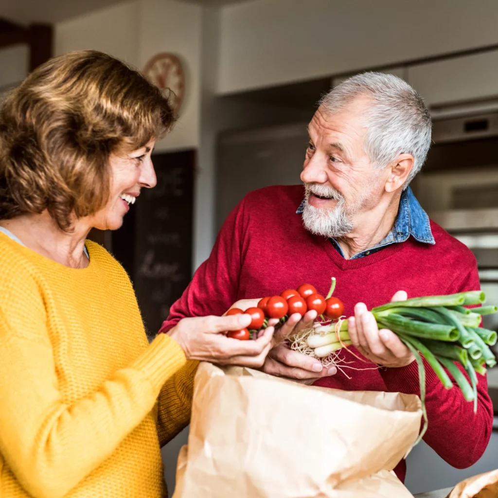 smiling-women-and-senior-with-fresh-produce-in-kitchen